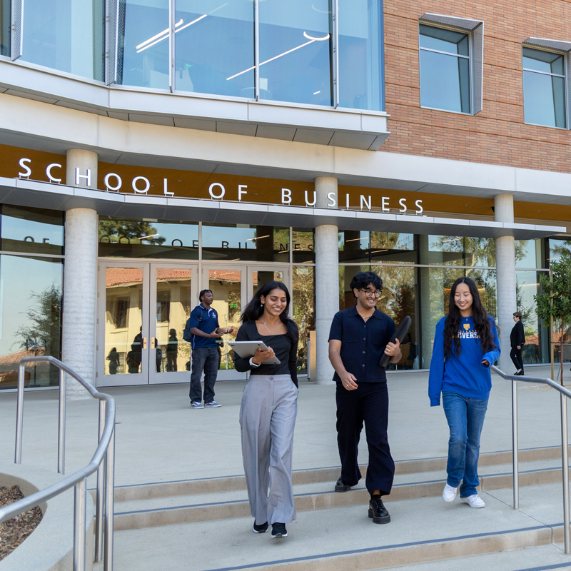 The Future of Business | Select to learn more A group of students walk away from UC Riverside's new School of Business building.